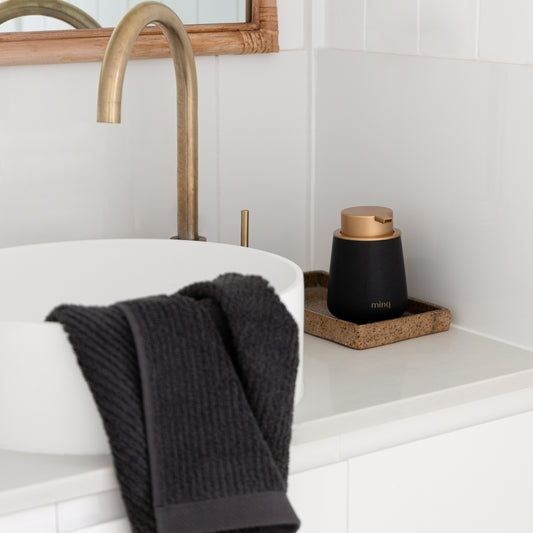 Black ceramic handwash dispenser in your bathroom with brass hardware